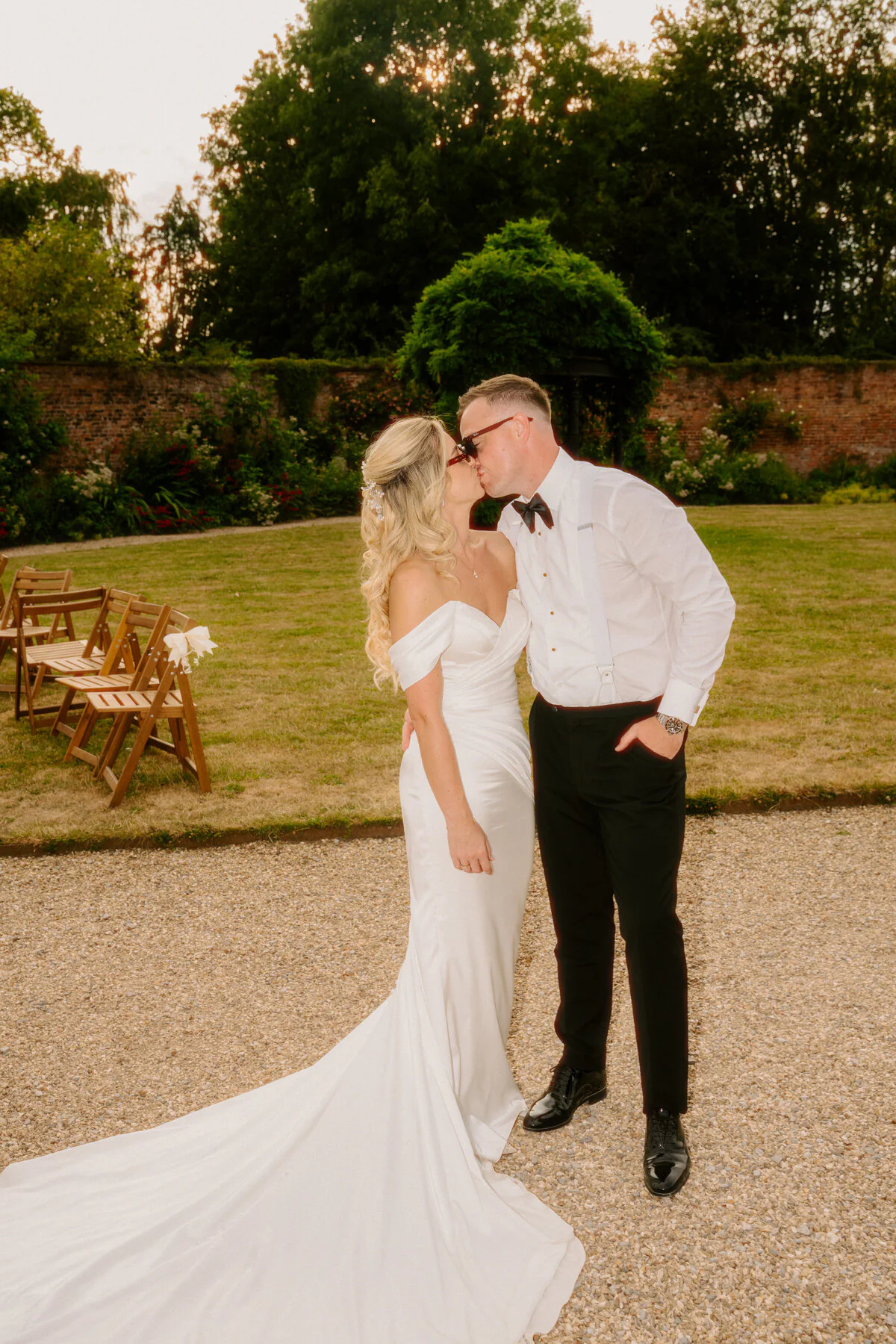 Ca104464 Edit Newlyweds sharing a kiss in the garden during relaxed wedding photography.