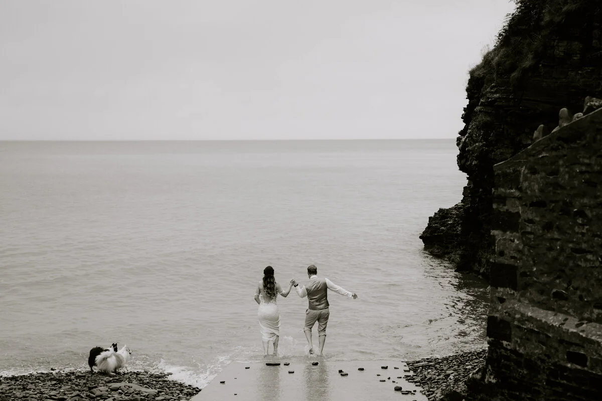 Dsc01336 Black and white photograph of a couple walking together along a rocky coastline.