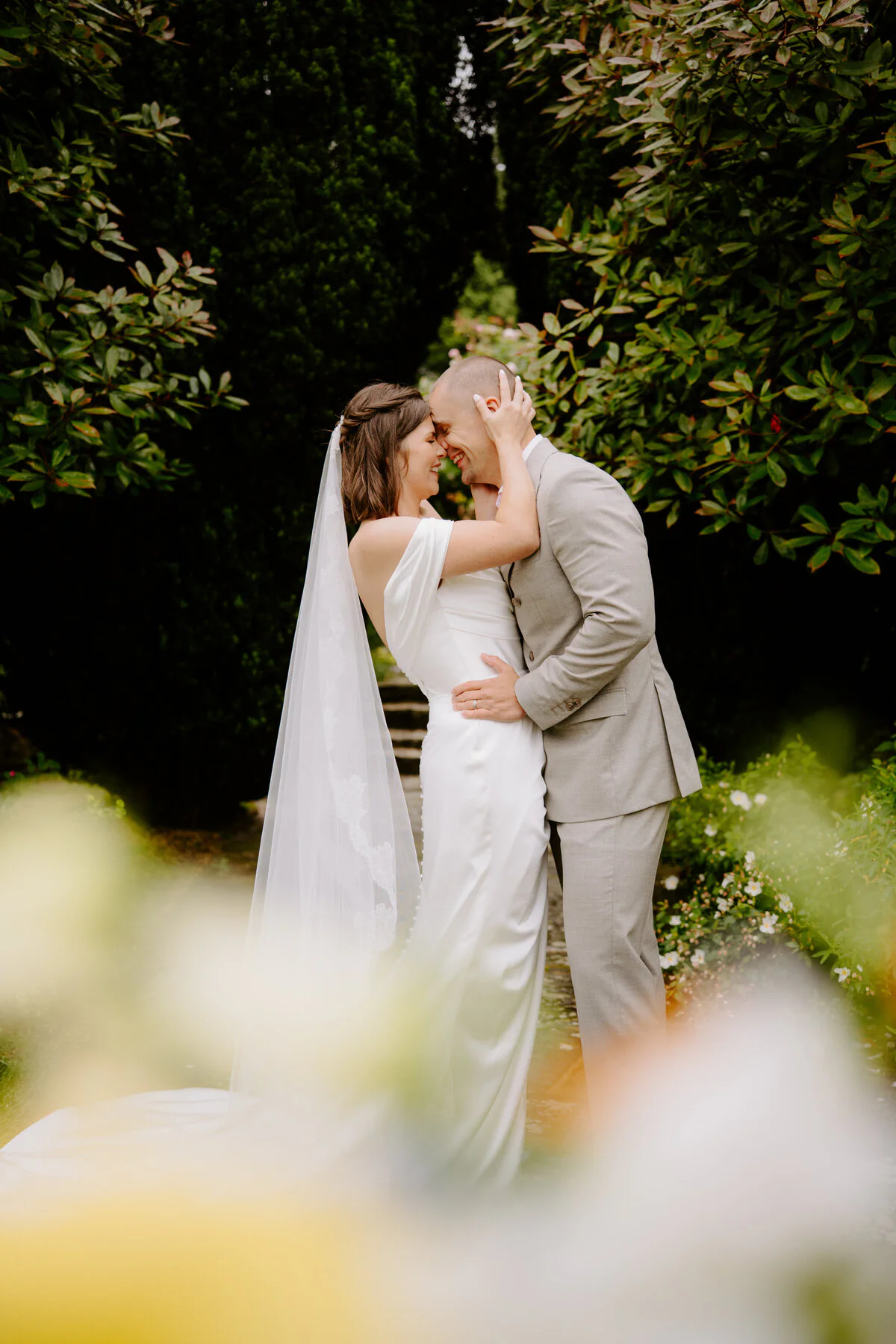 Dsc03813 Bride and groom sharing a quiet kiss in a leafy wedding venue garden.