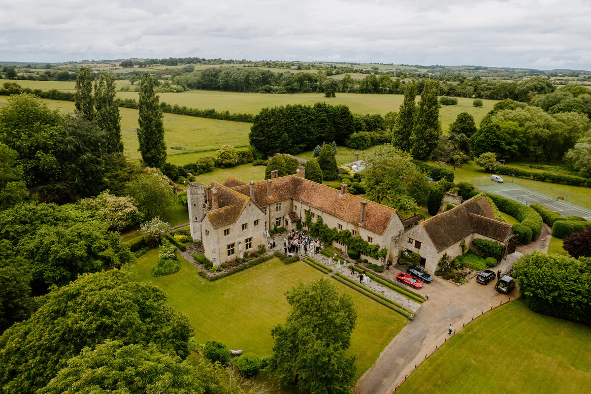 Charlie And Peter 462 Aerial drone photograph of Charlie and Peter's stone manor house wedding venue and courtyard.