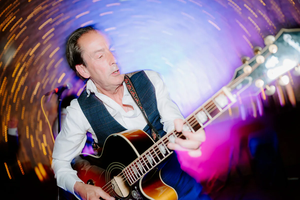 Dsc09612 Wedding guitarist playing beneath swirling colourful dance-floor light trails.
