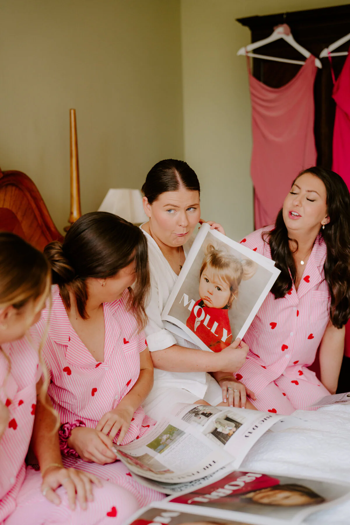 Dsc03167 Bride and bridesmaids in pink heart pyjamas looking at a magazine during morning prep.