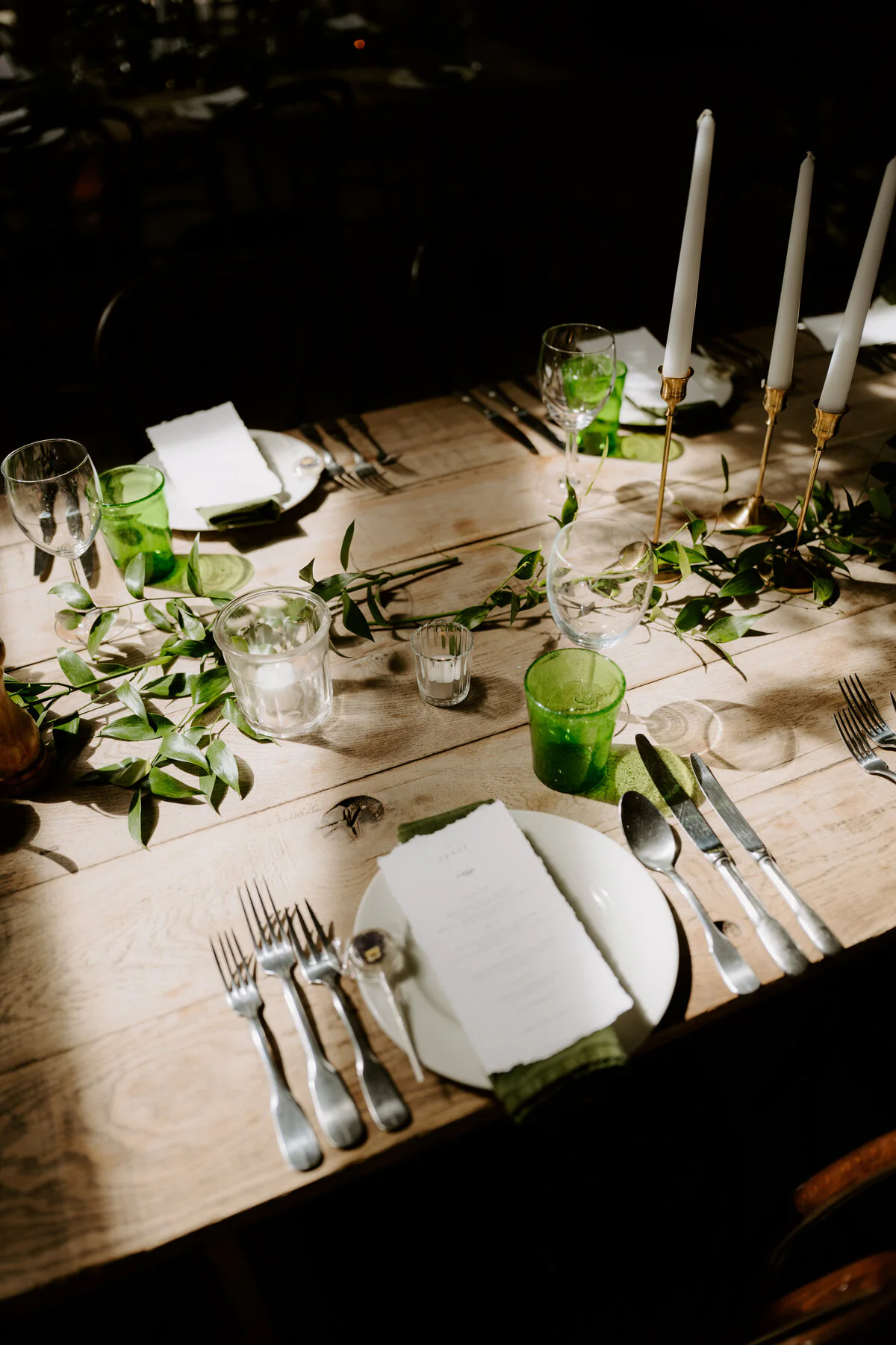 Dsc07530 Rustic wooden wedding breakfast table with a greenery runner, candles and green glassware.