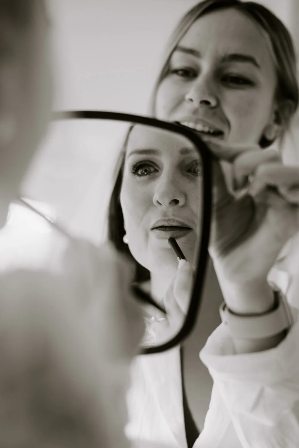 Dsc00588 32 31 Black and white photograph of a bride applying lipstick in a hand mirror.