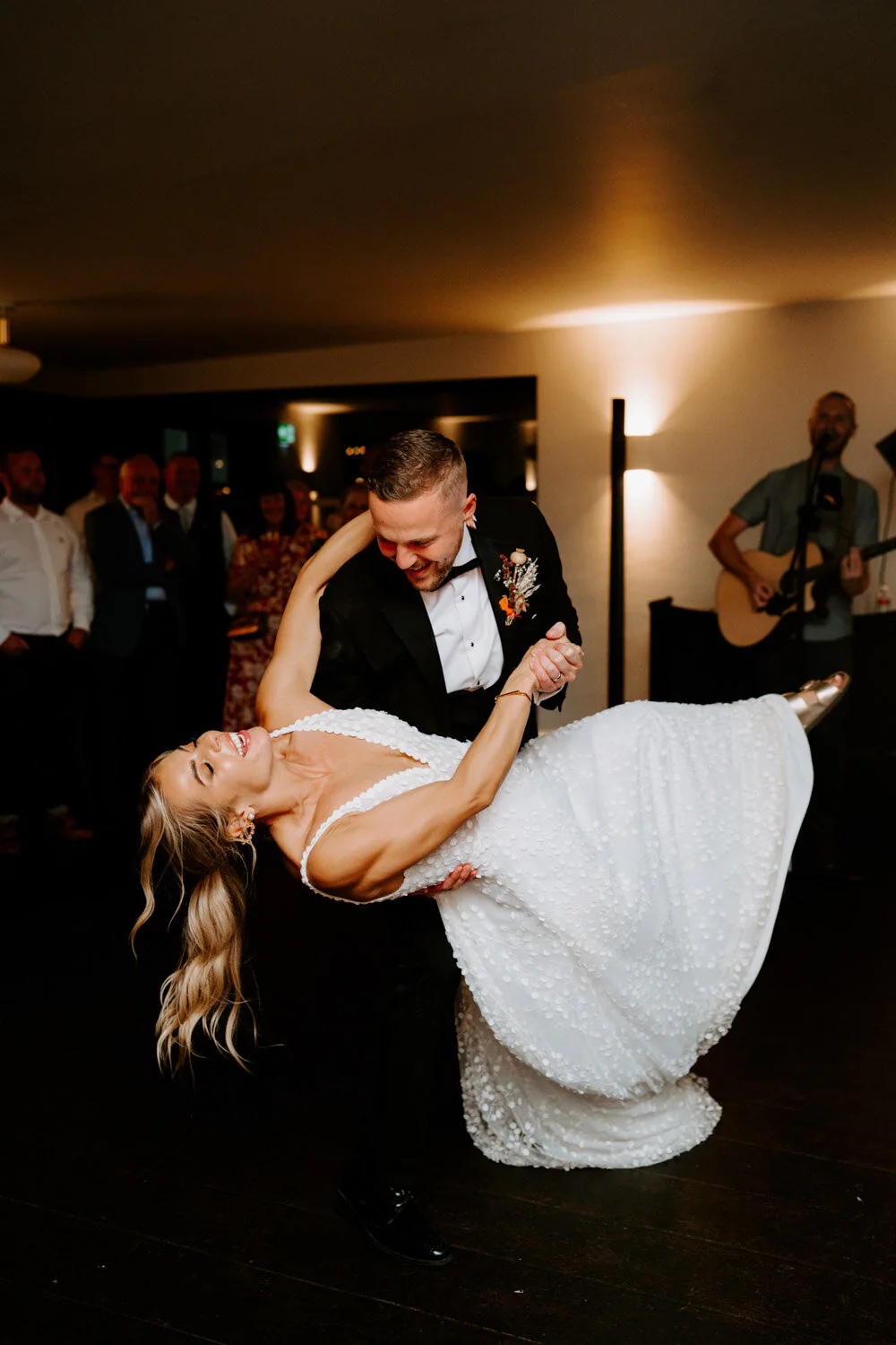 Dsc01502 12 Groom dipping the bride low during their first dance as a musician plays guitar.