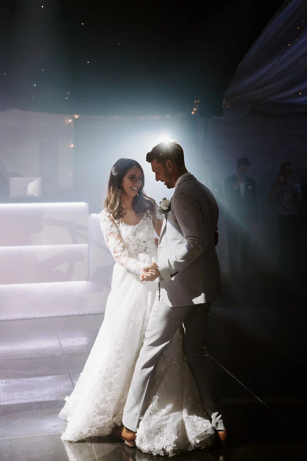 Jenny and Neil dancing together after dark, lit by a single spotlight